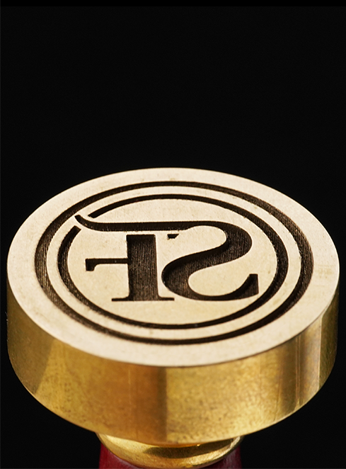 Perilla de color dorado con un logo grabado por láser de fibra A9 Ultra sobre un fondo negro